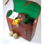A leather cased set of four lignum vitae bowling woods with sundry accessories