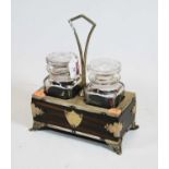 A Victorian calamander and silver plated tantalus, containing two cut glass decanters standing on