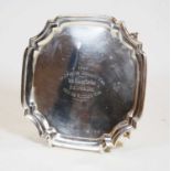 A George VI silver card waiter, of shaped square form, having raised piecrust rim, on scrolling