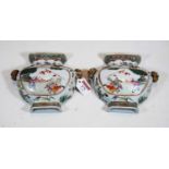 A pair of Chinese famille verte urn shaped wall pockets, decorated with figures and flanked by