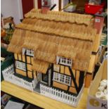 A modern dolls house in the form of the Five Chimneys public house, with faux thatched roofCondition