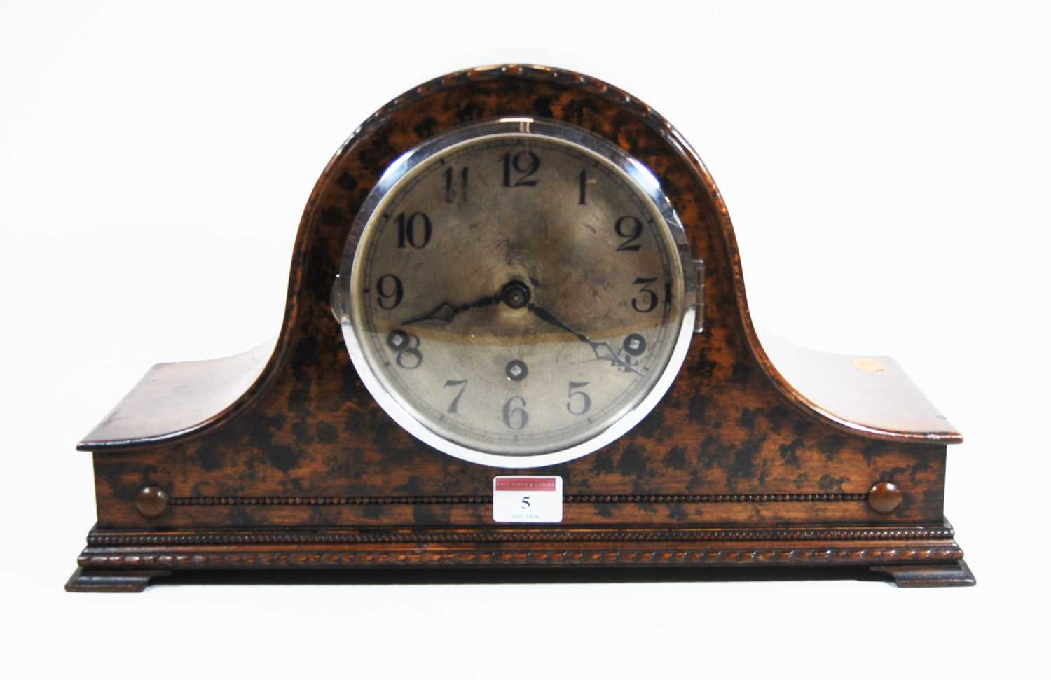 A 1930s walnut cased Nelsons hat mantel clock, the silvered dial showing Arabic numerals, the 8