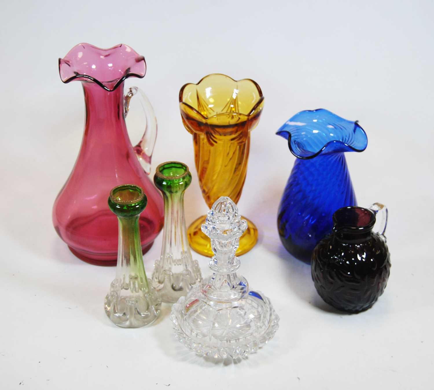 A collection of various coloured glassware to include a cranberry tinted water jug, height 24cm