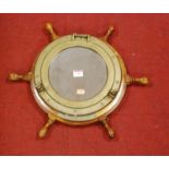 A wall mirror in the form of a ship's porthole and wheel, 47cm dia.