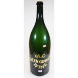 An oversized green glass bottle, inscribed Old Green Ginger Wine in gilt, height 66cm