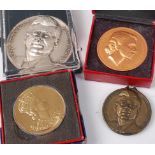 A QEII Coronation souvenir medallion, in box; one other; and two for John Kennedy (4)