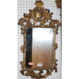 A small early 19th century floral carved giltwood framed wall mirror, with replacement mirrorplate