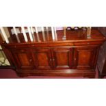 A contemporary joined cherry wood round cornered four-door side cupboard, having recessed panelled