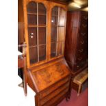 A 1930s figured walnut and crossbanded bureau bookcase, having twin glazed upper doors, w.81cm