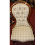 A mid-Victorian mahogany framed and buttoned fabric upholstered spoonback nursing chair, raised on