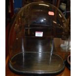 A Victorian glass clock dome, housed on an ebonised oval base, overall h.41cm; together with another