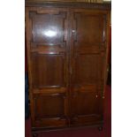 A 1920s geometric moulded oak double door wardrobe, enclosing hanging compartment and three lower