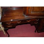 A circa 1900 mahogany ledgeback kneehole dressing table, having four frieze drawers on slender