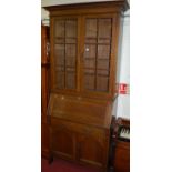An Arts & Crafts oak bureau bookcase, having twin glazed upper doors, w.97cm