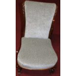 A Victorian faded rosewood framed and upholstered childs nursing chair, raised on scroll cabriole