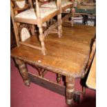A circa 1900 heavy floral relief carved oak extending dining table, having canted corners, wind-