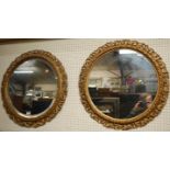 A pair of floral pierced gilt framed bevelled circular wall mirrors, dia.63.5cm