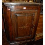 An early 19th century provincial walnut, fruitwood, star and chequer inlaid single door hanging