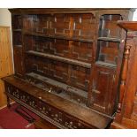 An extremely large geometric moulded oak dresser, the panelled back tiered open plate-rack fitted