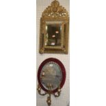 A circa 1900 gilt and embossed metal framed bevelled wall mirror, 59 x 31cm; together with a further