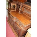 A good late 19th century profusely carved floral oak breakfront sideboard, the raised two panelled