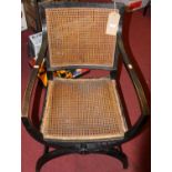 A circa 1900 ebonised cane back and seat X-frame elbow chair, w.57cm