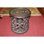 An African tribal stained hardwood circular stool, the surround decorated with standing figures,