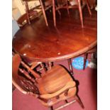 A contemporary stained pine circular dining table together, with a set of eight matching splatback