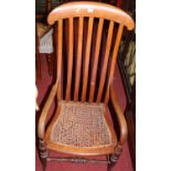 A late 19th century provincial walnut and cane seat slatback farmhouse open elbow chair (some damage