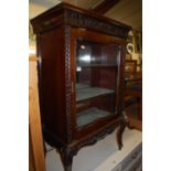 An Edwardian floral relief carved stained walnut single door glazed music cabinet, w.66.5cm