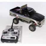 A Tamiya 1/10 scale radio controlled kit built model of a Toyota Hilux Hi-lift pickup truck 4x4