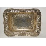 An Edwardian silver tray, of shaped rectangular form, having a repousee C-scroll decorated centre