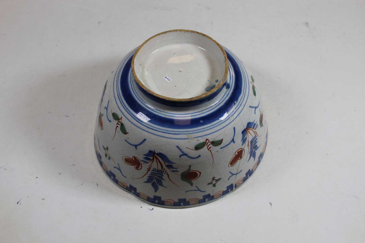 An 18th century English Delft bowl, decorated in shades of blue, brown and green, on circular foot - Image 3 of 3