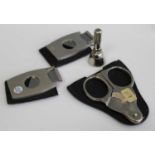 A steel scissor action pocket cigar cutter with leather sleeve, together with two other small pocket