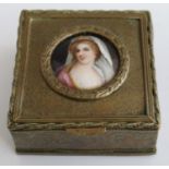 A 19th century brass trinket box with inset painted porcelain plaque to the lid decorated with a