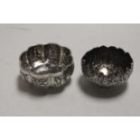 Two early 20th centurty Indian lobed and embossed silver sugar bowls, the largest dia. 10cm