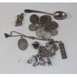 A small collection of miscellaneous items, to include a coin bracelet, silver teaspoon, silver charm