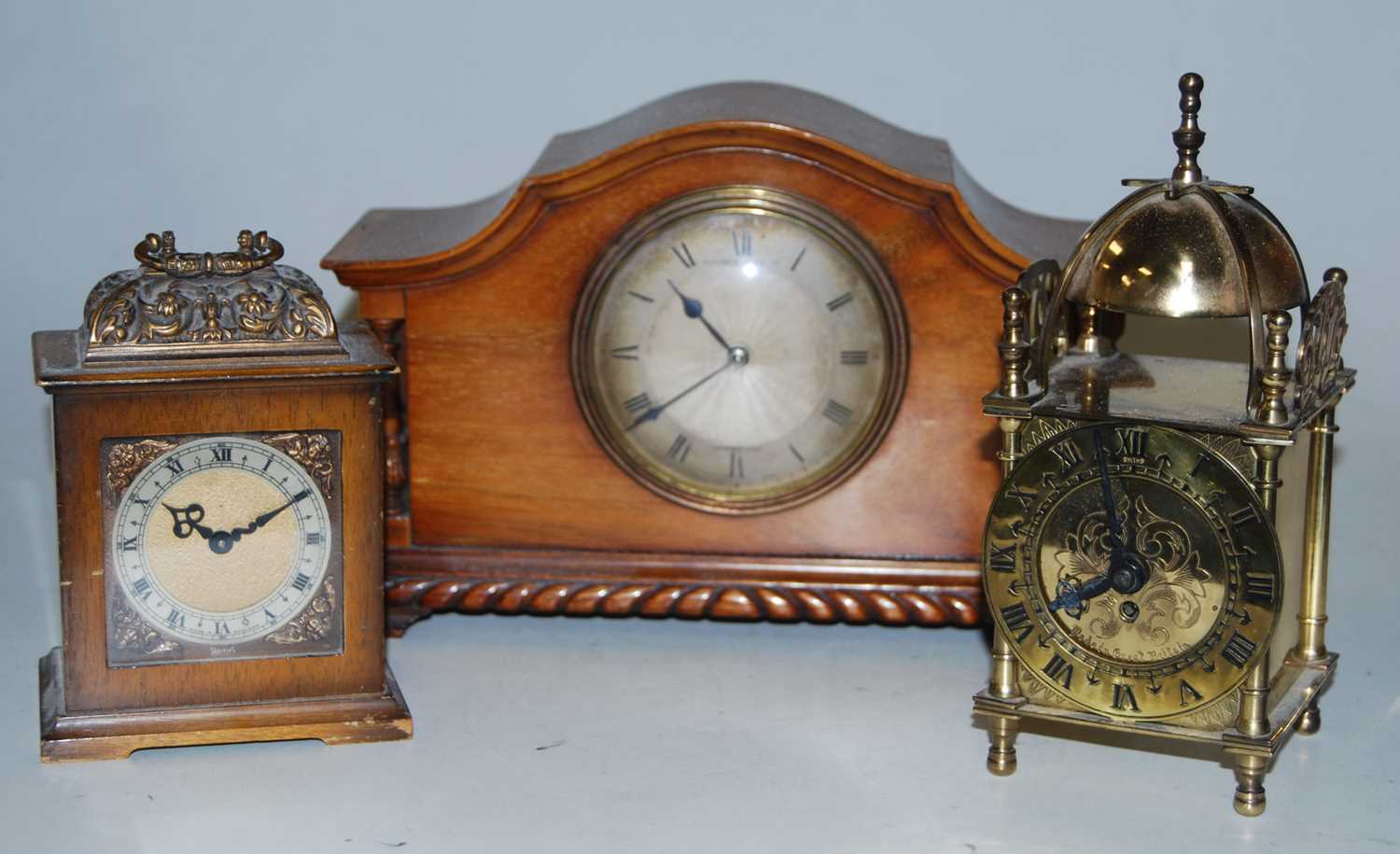 A 1920s walnut cased mantel clock having an engine turned silvered dial with Roman numerals signed