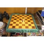 A modern travel chess board together with a set of carved wood and brass mounted chess pieces