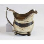 A George III silver cream jug of helmet shape on ball feet, weight 3.9oz