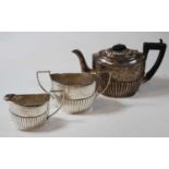 A late Victorian silver bachelors three-piece tea set, of half-gadrooned form, having engraved