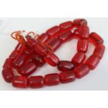 A faux cherry amber necklace, the oblong beads between 2.5 and 1.3cm long, gross length 62cm,