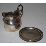 A George V silver cream jug of plain undecorated form having C-scroll handle, maker TH Hazelwood &