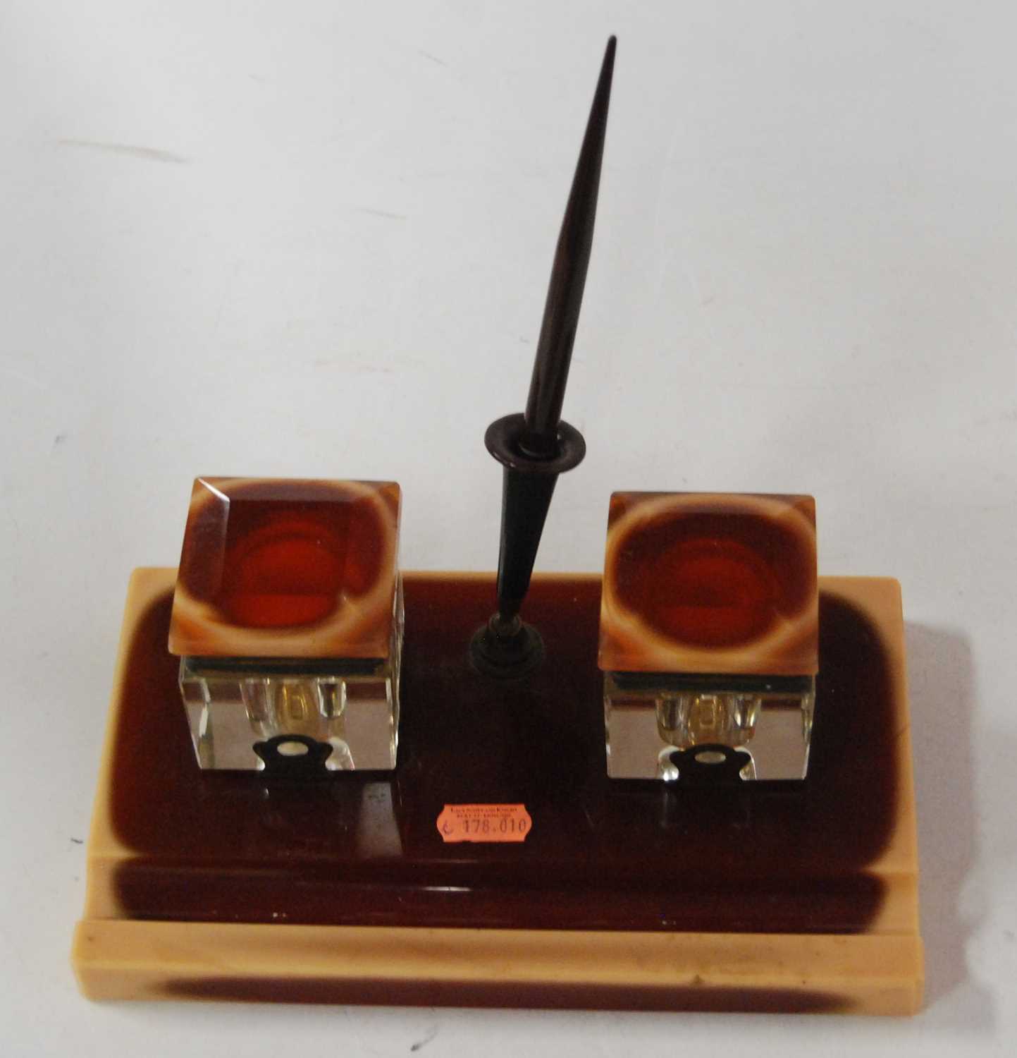 An Art Deco onyx desk stand having twin cut glass inkwells and central pen, w.23cm