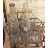 An original galvanised steel six division oil bottle holder containing four examples to include X100