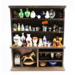 An oak dolls house dresser, containing an assortment of various dolls house accessories and