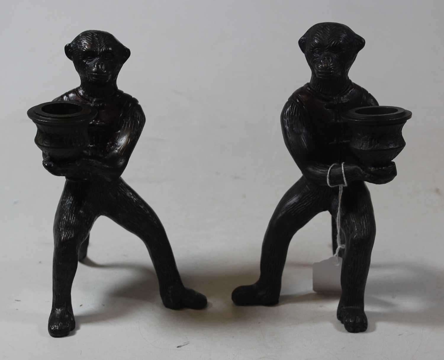 A pair of modern bronze figural candlesticks, each in the form of a monkey holding a sconce, h.16cm