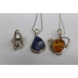 An amber inset pendant on finelink chain, together with a silver ring, and another pendant (3)