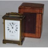 An early 20th century lacquered brass cased carriage clock having an enamel dial with Roman numerals