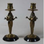 A pair of Egyptian Revival brass candlesticks, on slate base, h.21.5cm